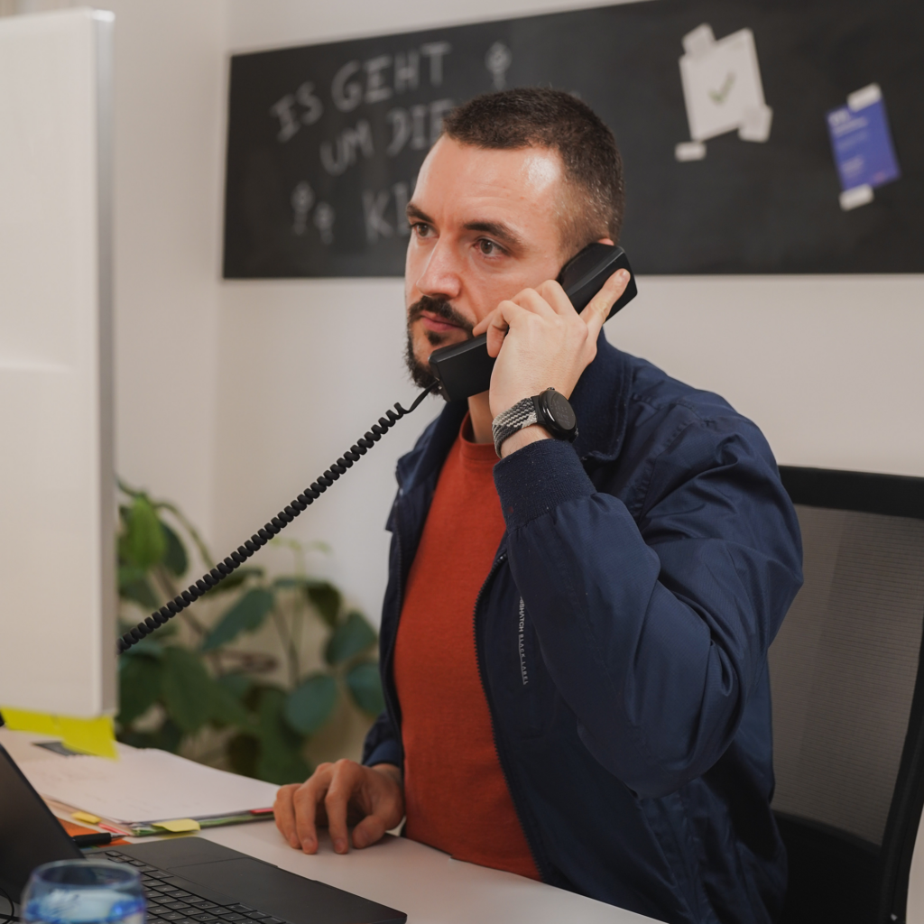 Technischer Support-Mitarbeiter für die Ausbildungshilfe beantwortet eine Frage am Telefon.